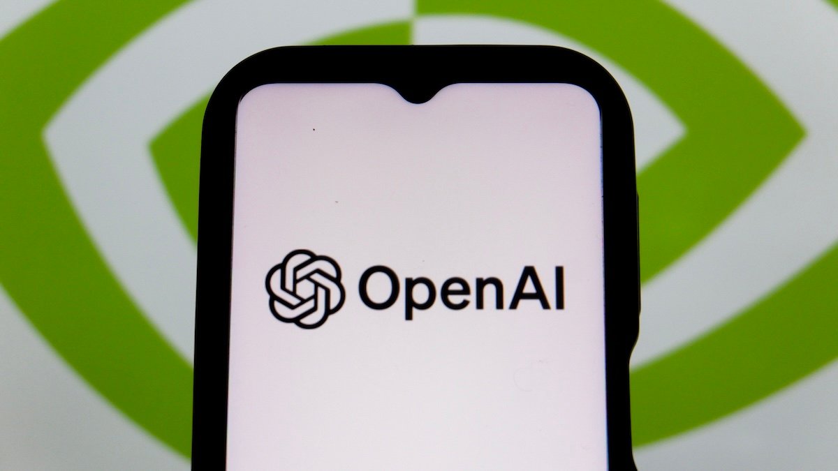 Ilustrasi logo OpenAI di layar ponsel dan komputer