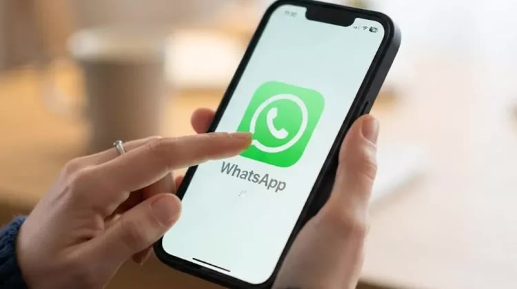 Ilustrasi tangan membuka aplikasi WhatsApp di ponsel