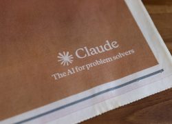 Ilustrasi logo Claude dari Anthropic pada lembar cetak berwarna cokelat